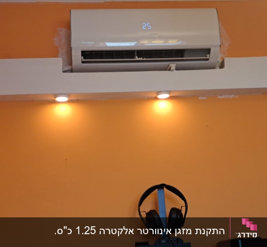 מזגן מותקן על קיר כתום עם אורות תקרה
